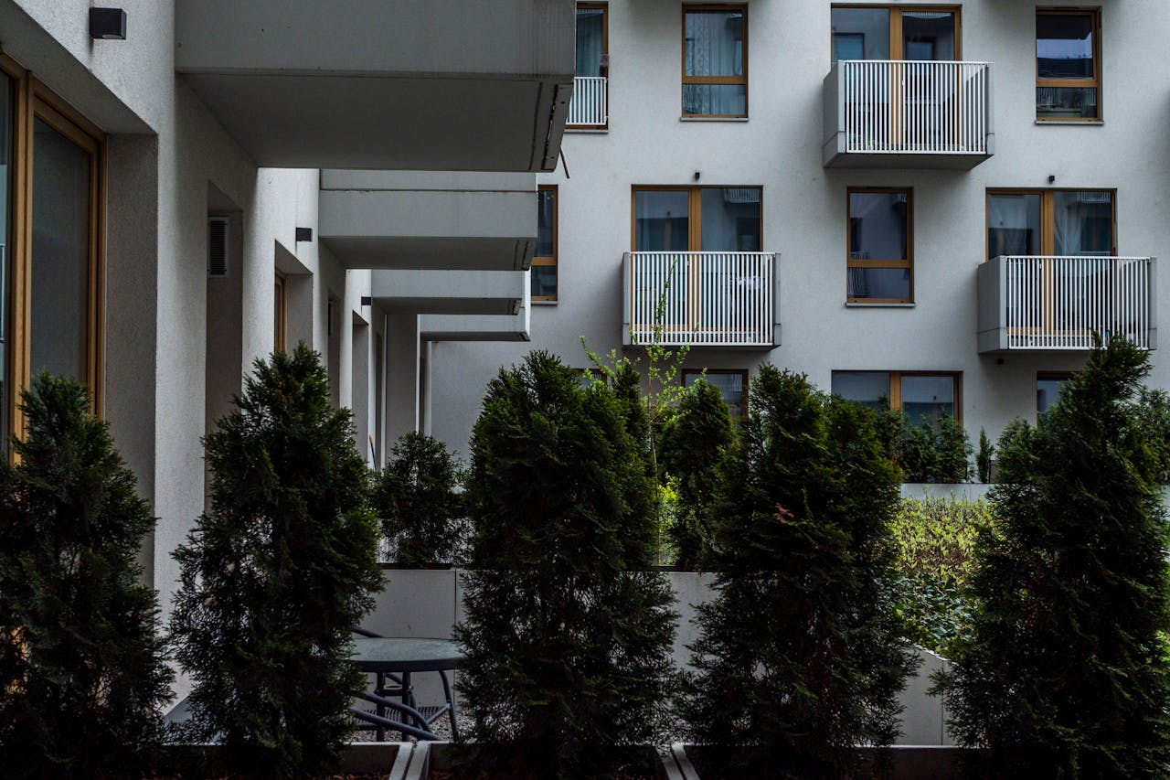 Modern apartment building with balconies and lush greenery for an urban lifestyle vibe.