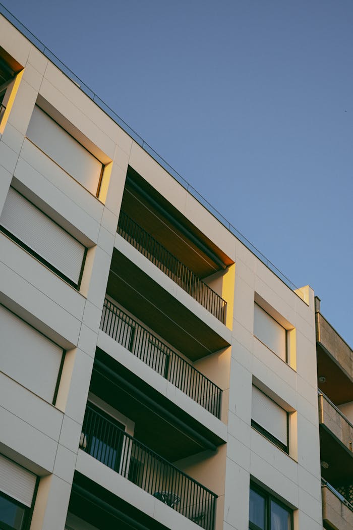 Contemporary apartment exterior with balconies and sunset lighting.